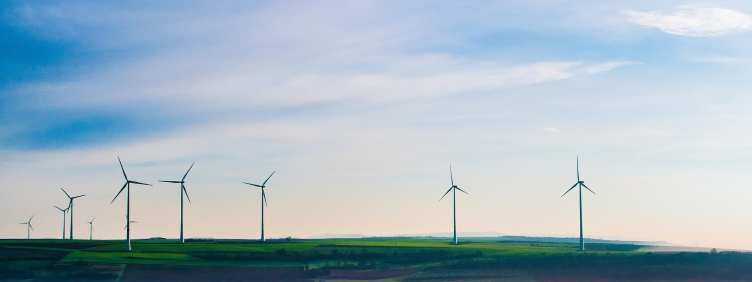 Ten windmills spinning in a field